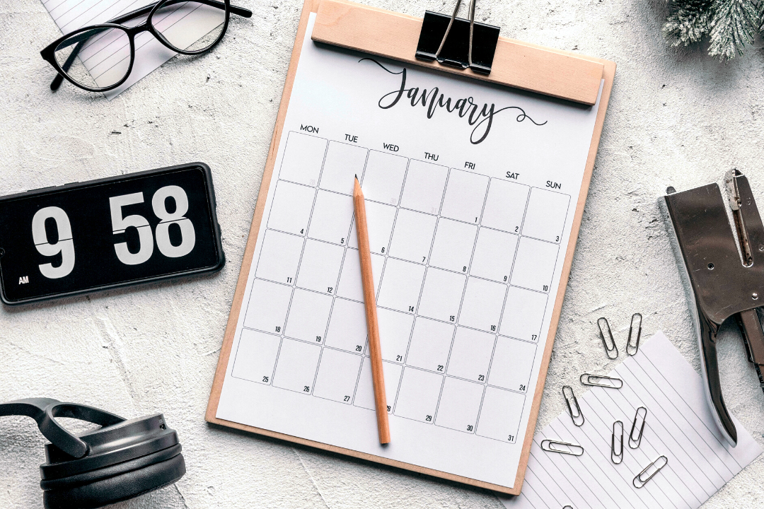 A calendar, digital clock and glasses