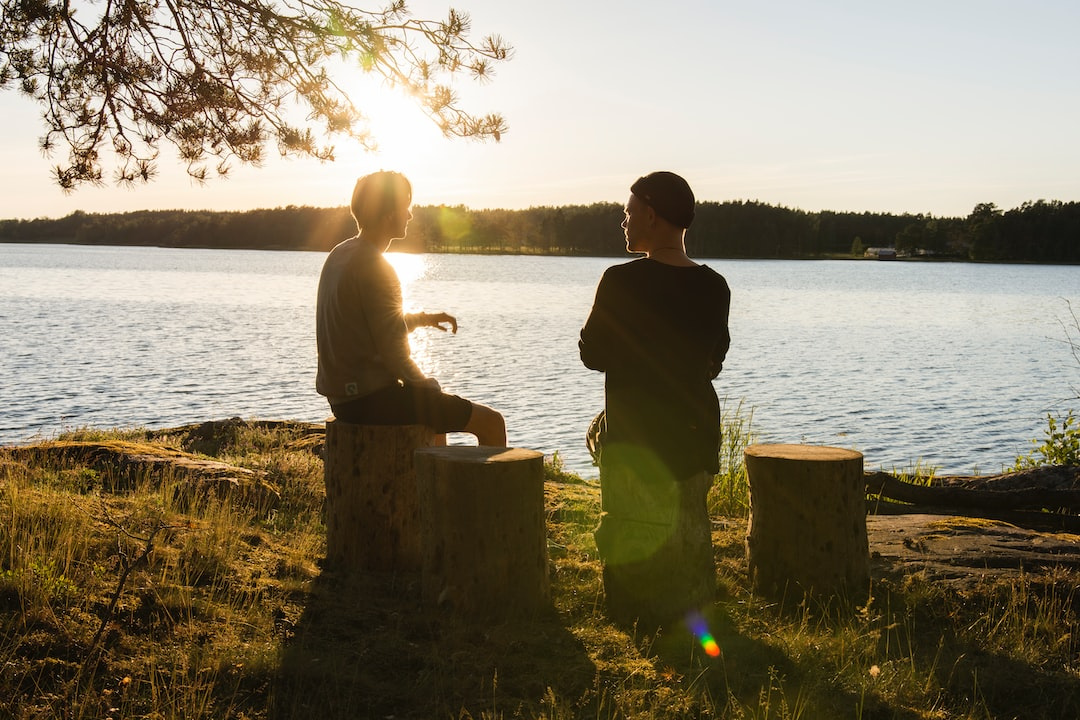 Two men sitting by the lake at sunset