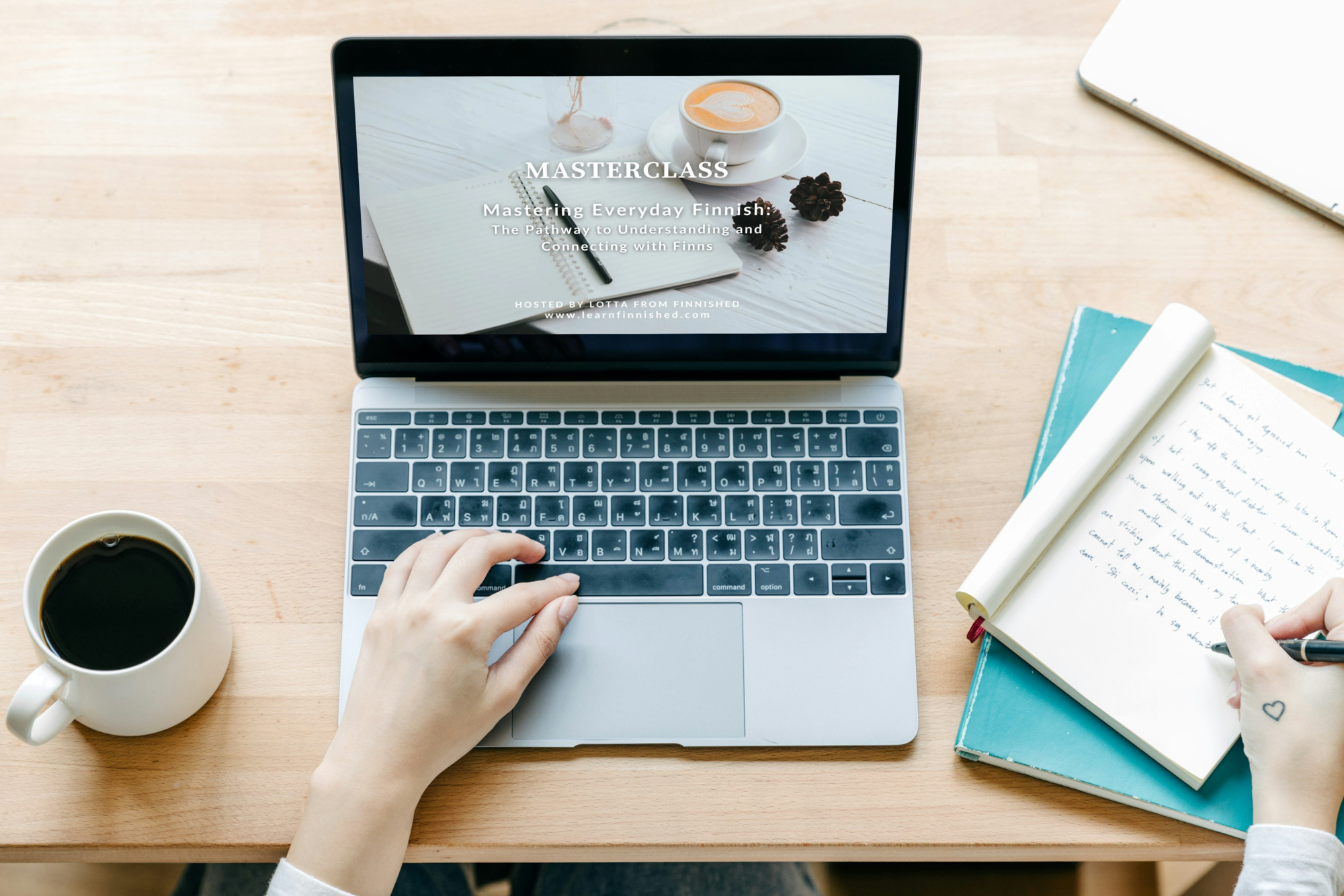 Laptop and a person taking notes with a coffee