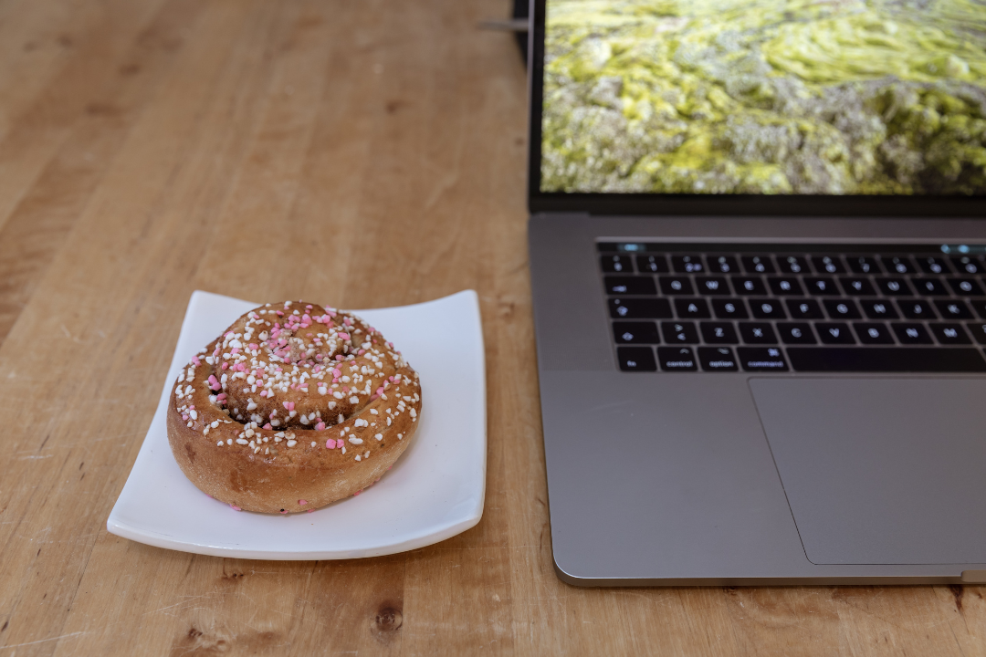 A cinnamon bun and a laptop